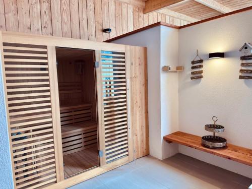 カランテックにあるVilla le 25 - Piscine et Sauna au bourg de Carantecのクローゼット(木製のシャッタードア付)が備わる客室です。