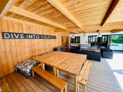 カランテックにあるVilla le 25 - Piscine et Sauna au bourg de Carantecの部屋にある木製のテーブルと木製のデッキ