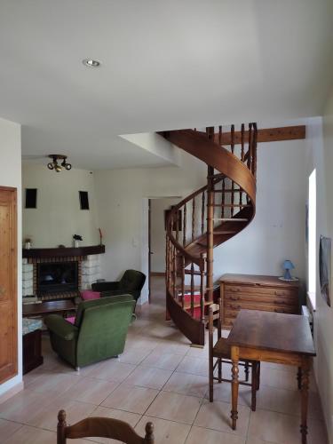 - un salon avec un escalier en colimaçon et un canapé dans l'établissement Gite des trois ormeaux, à La Celle-sous-Gouzon