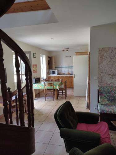 un salon avec une table et une cuisine dans l'établissement Gite des trois ormeaux, à La Celle-sous-Gouzon