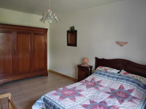 une chambre avec un lit avec une couette dessus dans l'établissement Gite des trois ormeaux, à La Celle-sous-Gouzon