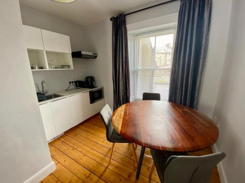 a kitchen with a table and chairs in a room at 6 New Street Bantry Selfcatering BnB Apartment 1 in Bantry