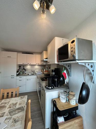 a kitchen with white cabinets and a microwave at Herzensnest mit Grüntenblick in Immenstadt in Immenstadt im Allgäu