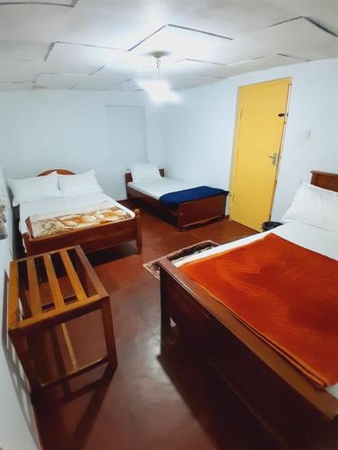 a room with two beds and a chair in it at Green Villa in Nuwara Eliya
