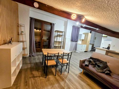 un salon avec une table, des chaises et un canapé dans l'établissement Grand 2 chambres centre Foix stationnement juste devant le logement, à Foix