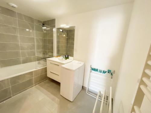 une salle de bain blanche avec un lavabo et une douche dans l'établissement Joli T3 au coeur de Sanary avec garage, à Sanary-sur-Mer