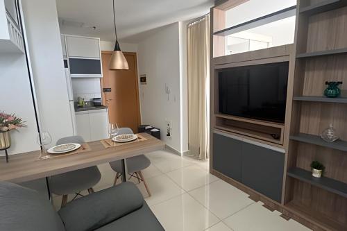 a living room with a table and a television at Apt de Luxo III no Shopping DF Plaza - Aguas Claras in Brasilia