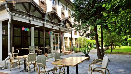 a patio with tables and chairs in front of a building at Salgó Hotel in Salgótarján