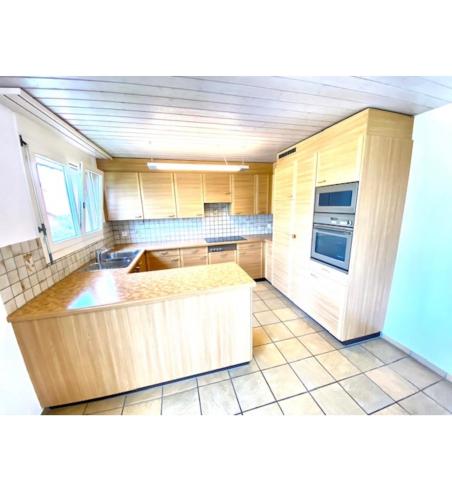 a kitchen with wooden cabinets and a counter top at Private room in Schänis for more than 3 guests the entire place is yours in Schänis
