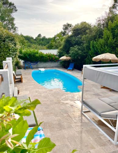 a swimming pool in a yard with chairs and trees at TORTINETTE in Sainte-Anastasie-sur-Issole