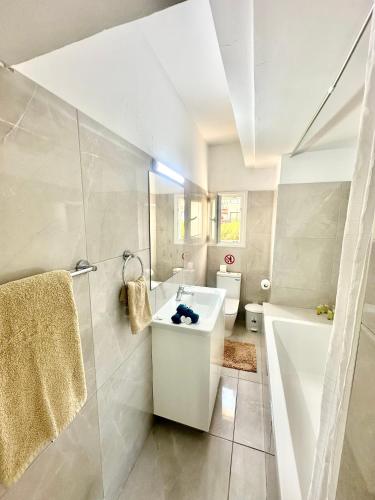 a bathroom with a sink and a tub and a toilet at Mediterranean Blue - Secret Escape in Limassol