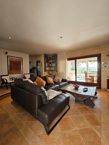 Una sala de estar con un sofá de cuero y una mesa. en Ca n'Estrella, en Santa Gertrudis