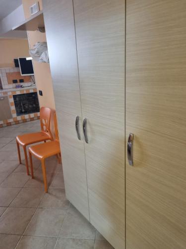 a wooden cabinet in a room with a chair at Casa a mare Piscitelli in Mondragone