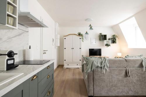 a living room with a couch and a kitchen at MonSéjourCosy - Le Cottage - Studio - Cosy - Netflix in Mulhouse