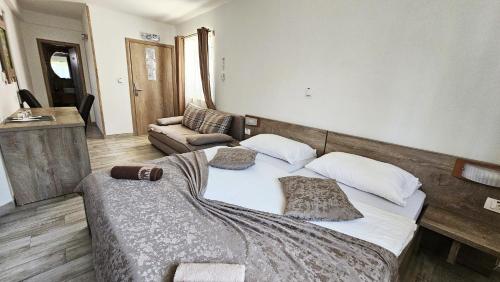 a bedroom with a large bed and a couch at SEDRA Holiday Resort-Adults Only-Bed & Breakfast in Grabovac