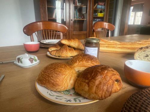 Una mesa con tres platos de croissants encima. en Domaine La Perruche Parenthèse poétique Vue Mont-Saint-Michel & Petit-déjeuner festin, en Servon