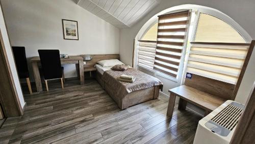 a bedroom with a bed and a desk and a table at SEDRA Holiday Resort-Adults Only-Bed & Breakfast in Grabovac