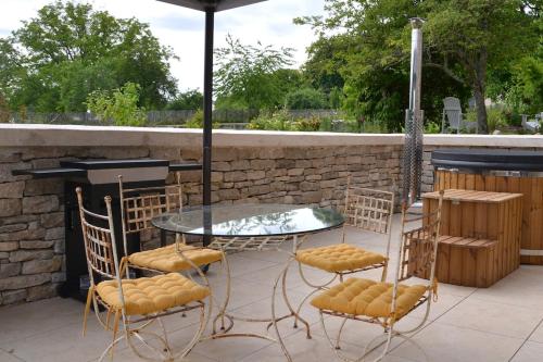 a table and chairs with an umbrella on a patio at Gite L étable du Bien Etre in Léré