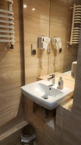 ein Badezimmer mit einem weißen Waschbecken und einem Spiegel in der Unterkunft Villa Pallas in Danzig