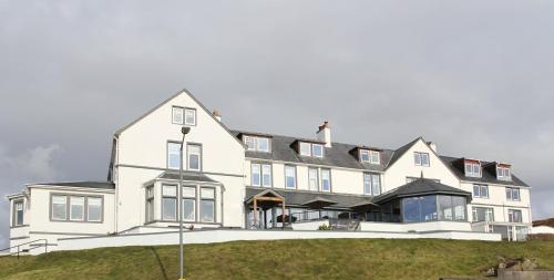 ein großes weißes Haus mit schwarzem Dach in der Unterkunft West Highland Hotel in Mallaig