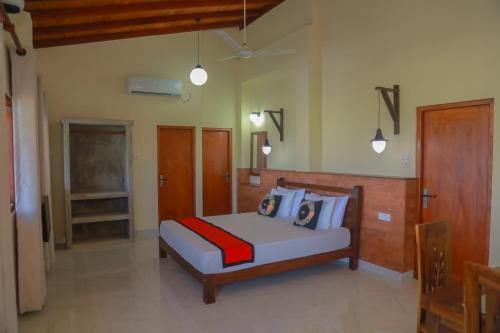 a bedroom with a bed and some pendant lights at Athithi Villa in Hikkaduwa