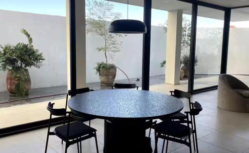 a dining room with a black table and chairs at Departamento centro de Zapopan por Auditorio Telmex in Guadalajara