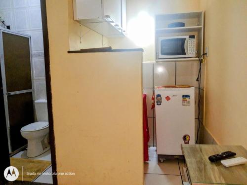 a small kitchen with a refrigerator and a microwave at Brisa Do mar Apartamento 2 in Cabo Frio