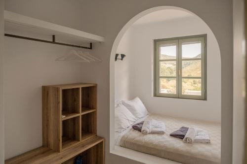 a small bedroom with a bed and a window at VERANNA Patmos D3 in Patmos