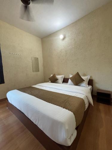a bedroom with a large bed with white sheets and pillows at TownHill Homestay in Bhīm Tāl