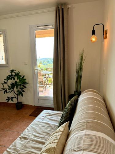 un salon avec un canapé et une porte coulissante en verre dans l'établissement Peaceful apartment with sea and hill view, air-conditioned, à Roquebrune-sur Argens