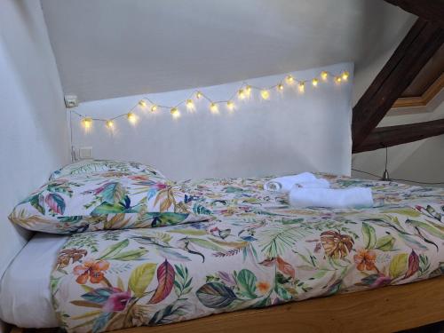 - une chambre avec un lit doté d'une couette et d'oreillers à fleurs dans l'établissement Bords de Loire - Climatisé - 4 personnes - Hypercentre Orléans, à Orléans