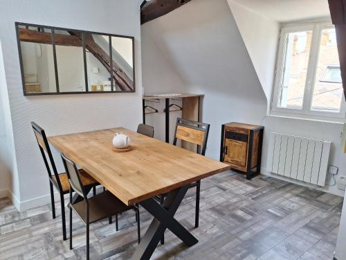 une salle à manger avec une table et des chaises en bois dans l'établissement Bords de Loire - Climatisé - 4 personnes - Hypercentre Orléans, à Orléans