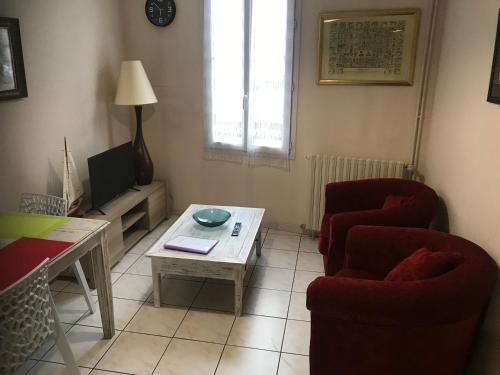 un salon avec deux chaises et une table basse dans l'établissement residence pasteur - Hermione, à Rochefort