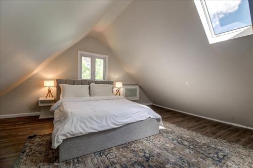 a attic bedroom with a bed and a window at 7BR Spacious Property Perfect For up to 15! in Orange