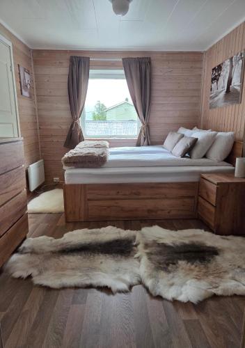 a bedroom with a bed with fur rugs on it at En liten hytte i Gryllefjord in Gryllefjord
