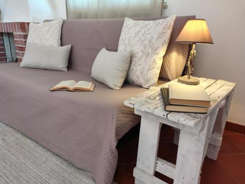 a bed with two books and a table with a lamp at L'olivo - Meridiana case al mare in Mattinata