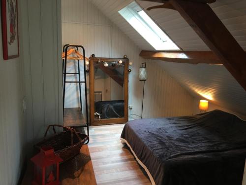 una camera da letto con un letto e un grande specchio di Toit et Moi a Le Mont-Dore