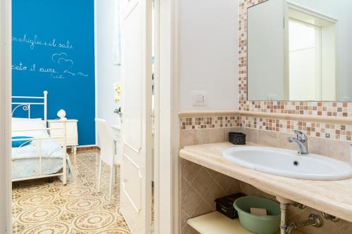 une salle de bain avec un lavabo et un miroir dans l'établissement Casa Poesia, à Torre San Giovanni