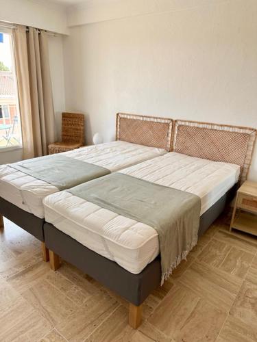 un grand lit dans une chambre avec une fenêtre dans l'établissement AGENCIA Appartement residence Oxford 5e, à Cannes