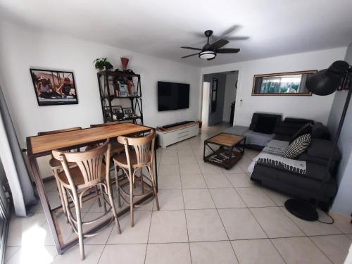 un salon avec une table, des chaises et un canapé dans l'établissement Appartement 2 CH résidence calme et arborée , proximité plages et commerces, à Toulon