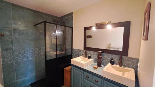 La salle de bains est pourvue de 2 lavabos, d'une douche et d'un miroir. dans l'établissement Mas la Provinciale, à Malaucène
