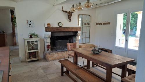 un salon avec une table et une cheminée dans l'établissement Mas la Provinciale, à Malaucène