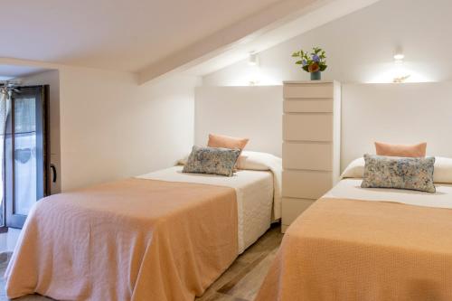 a bedroom with two beds with orange sheets at Apartaments La Cabana in Altafulla