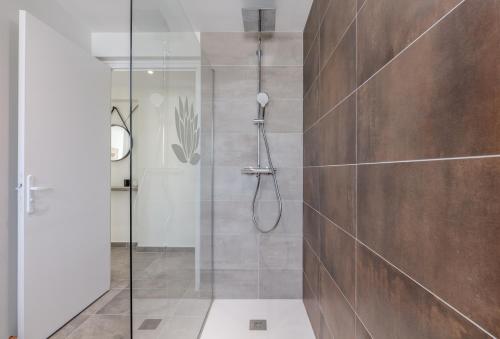 une salle de bain avec une douche avec une porte vitrée dans l'établissement Le Lonsois - T3 lumineux avec extérieur, à Pau