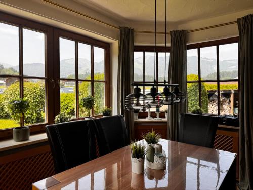 a dining room with a table and chairs and windows at Kerstin's Fewo Allgäuliebe in Fischen