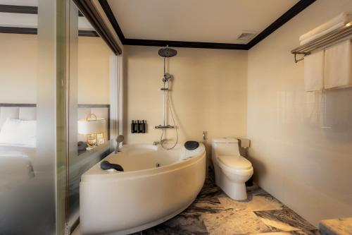 Un baño con bañera y WC. en FTE Ha Long Hotel, en Ha Long