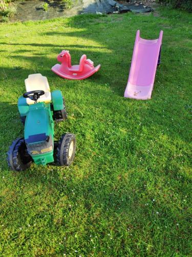 two toy trucks and a pink playset in the grass at gite campagne Aupthiesomme au calme entre terre et mer in Brailly-Cornehotte
