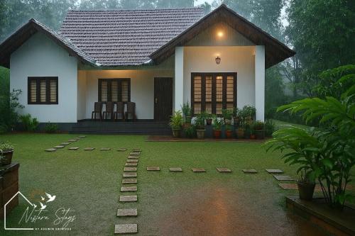 a small house with a green lawn in front of it at The Greeen Pod- Adamya Homestay in Aldūr