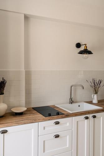 a kitchen with white cabinets and a sink at VERANNA Patmos D2 in Patmos