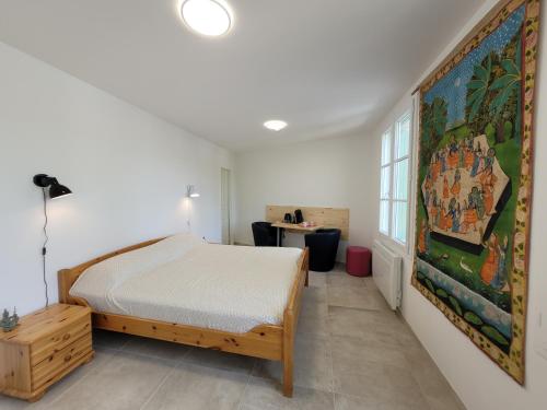 une chambre avec un lit et un tableau au mur dans l'établissement Tout prêt, tout près du fort, à Saint-Georges-dʼOléron